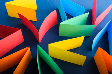 Multicolored cut paper on blue. Abstract arrows, direction signs. - obrazy, fototapety, plakaty