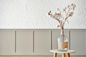 Cotton flower in the glass vase on the table, modern decorative wall room background style.