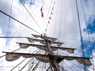 Fototapeta premium Tall ship masts with rigging and country flags flappy in wind