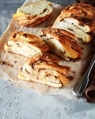 Cinnamon twisted loaf bread or babka on a dark wooden background, still life, rustic style