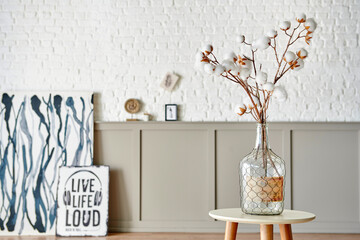 Cotton flower in the glass vase on the table, modern decorative wall room background style.