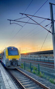 Brecht, Belgium - June 2019: A commuter train of there Belgian Railways (NMBS/SNCB) in the Noorderkempen railway station in Brecht heading to the Antwerp Central railway station at the break of dawn
