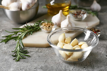 Bowl with garlic on grey background