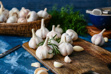 Board with fresh garlic on color background