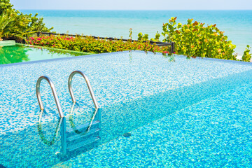 Fototapeta na wymiar Umbrella and chair around outdoor swimming pool in hotel resort