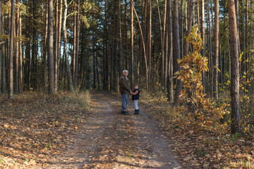 Happy child with Grandfather playing at the forest. Grandpa retiree. Retirement parent. Portrait of...