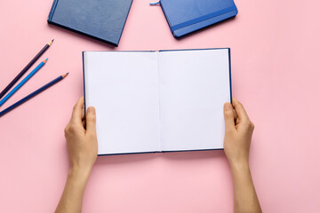 Obraz premium Female hands with blank book on color background