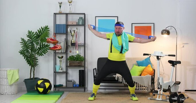 Fitness parody. Humor in sports. Expressive fitness guy doing training at home . Sports and comedians concept.
