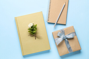 Blank book, notebook and gift box on color background