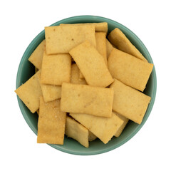 Cheese and garlic snack crackers in a green bowl isolated on a white background top view.