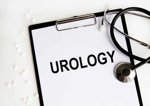 On the letter tablet is the text UROLOGY, next to the stethoscope and white tablets.
