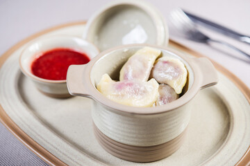 portion of sweet ukrainian russian polish dumplings stuffed with cherry in a ceramic pot served with cherry jam