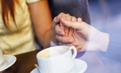 Fototapeta na wymiar Romantic background, two cups of coffee and hands of couple in love on date. Romantic dinner in valentine's day