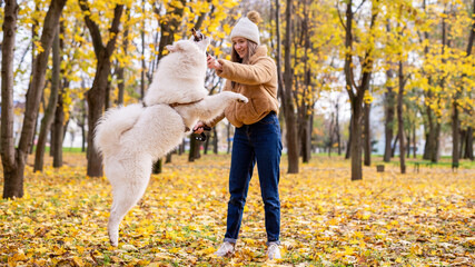 Woman with her dog in a park, autumn