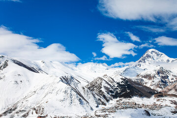 Fototapeta premium Kazbegi Mountain Winter View with Blue Sky