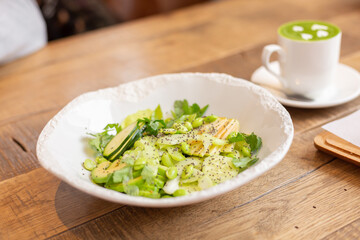 Healthy breakfast in the restaurant. Green salad with avocado, pear, white beans