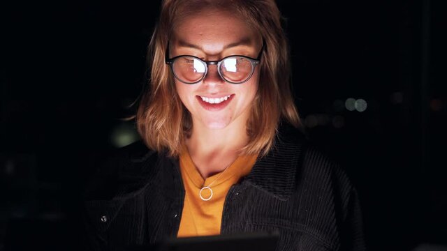 Caucasian business woman smiling while successfully closing business deal working late at night in office