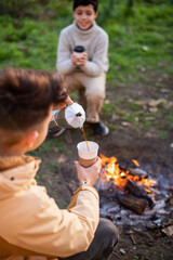 Two boys making coffee on a picnic