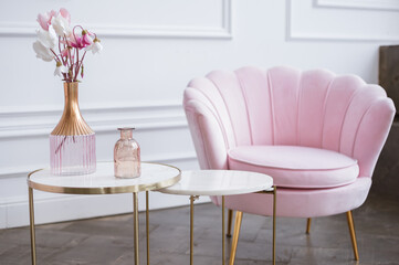 Pink flowers in a glass vase on a marble dressing table. Light interior. Interior design concepts.