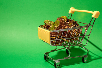 shopping cart filled with gold coins set against a blue background