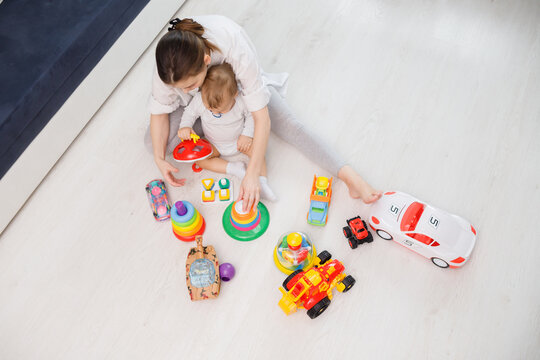 Top View On Woman's And Child Playing With Toys Wooden On Floor