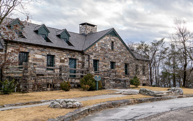 A stone building  with peak roof and a large chimney and trees in winter, Bald Rock Lodge, Cheaha State Park, Alabama
