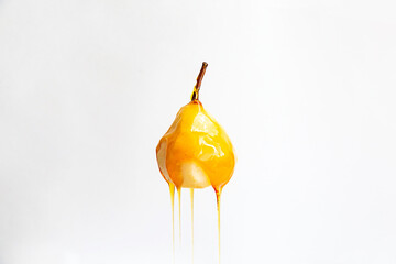 Pear in caramel syrup isolated on white background. Vegan and healthy food concept