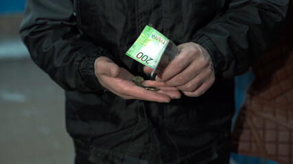 A male worker of Caucasian nationality received Russian rubles for a working day. A male worker holds money in his hands and counts it