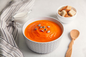 Pumpkin soup-puree with cream and seeds on a white background, selective focus