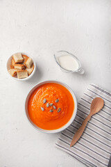 Pumpkin soup-puree with with breadcrumbs, cream and seeds on a white background. Copy space