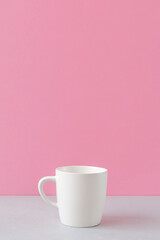 Fototapeta na wymiar Mug on the table and pink wall. Simple style, drink, cute, blank material, rest, break time, drink time, coffee, etc. テーブルの上のマグカップとピンク色の壁。シンプルスタイル、ドリンク、かわいい、ブランク素材、休息、休憩時間、ドリンクタイム、コーヒーなど