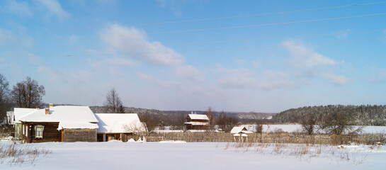 Fototapeta na wymiar Winter landscape in rural terrain with village on background sky with cloud