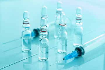 Syringe for injection and how many ampoules are on the glass surface.