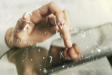 Double exposure of creative scientific formula concept with finger clicks on a digital tablet on...