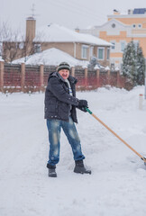 Snow collapse, man cleaning snow at winter weather with a shovel on a yard, winter trouble concept