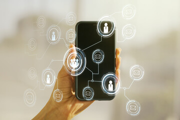 Double exposure of social network icons concept and hand with cellphone on background. Networking concept