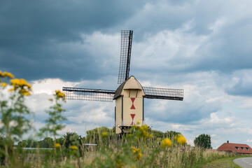 Dutch windmill in the country at dyke on a cloudy day
in the Netherlands.