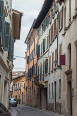 Fototapeta na wymiar Beautiful narrow alley with many windows in Brescia city. Historical architecture of the Lombardia region in Italy. Winter journey in North Italy. Travelling Europe. 