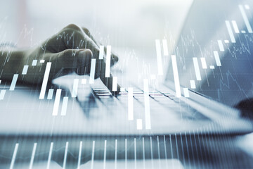 Multi exposure of abstract creative financial graph with hand typing on laptop on background, forex...