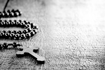wooden rosary in black and white photo, concept of christian faith and spirituality, space for text