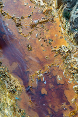 top down abstract view of a riverbed in an abandoned mining area with mineral and metal deposits in shallow water
