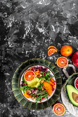 Vegan, detox Buddha bowl with avocado, persimmon, blood orange, nuts, spinach, arugula and pomegranate. Healthy balanced eating. Top view. vertical image