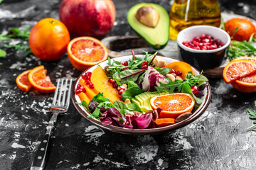 Vegan, detox Buddha bowl recipe avocado, persimmon, blood orange, nuts, spinach, arugula and pomegranate on a light background, top view