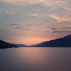 landscape with pink sunset. Seascape with mountains and cloudy sky