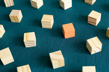 Group of wooden blocks and one different color block on blue background. Different opinion,...