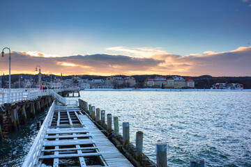 Fototapeta premium Beautiful sunset over the snowy pier (Molo) in Sopot at winter. Poland
