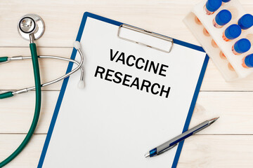 Worksheet with the inscription Vaccine Research, stethoscope and pen