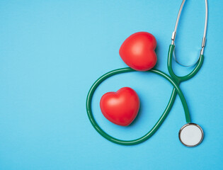 medical stethoscope and red rubber heart on a blue background