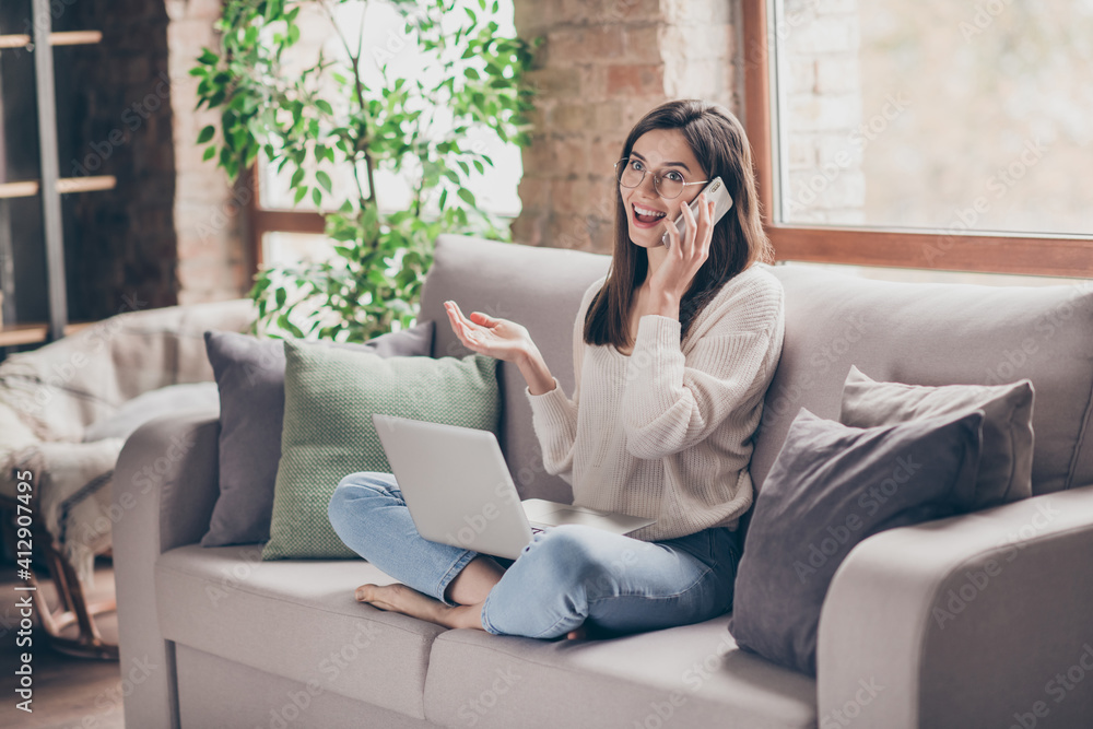 Sticker Photo of charming happy girl sit living room couch speak phone relax inside house wear sweater jeans indoors home