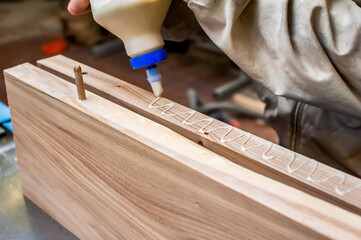 Gluing boards in a carpentry workshop. Connecting with dowels and glue. Manufacturing of furniture...